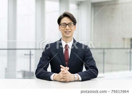 A businessman in a suit looking at the camera A businessman in a suit looking at the camera 79813964