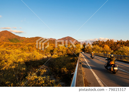 Motorcycles going on Fukushima National Highway 115 in autumn colors 79815317