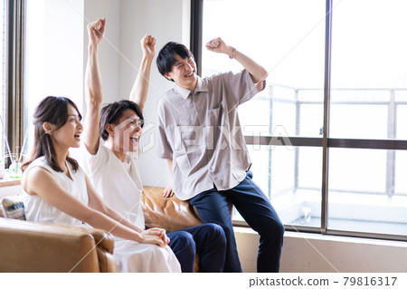 觀看體育比賽而興奮的年輕男女 觀看體育比賽而興奮的年輕男女 79816317