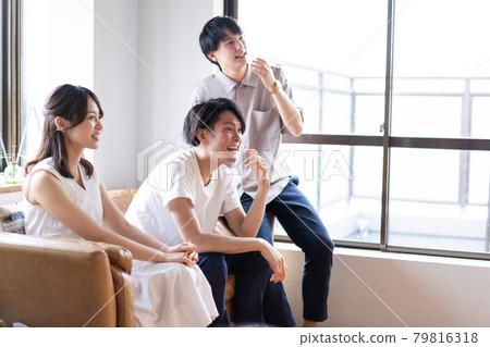 觀看體育比賽而興奮的年輕男女 觀看體育比賽而興奮的年輕男女 79816318
