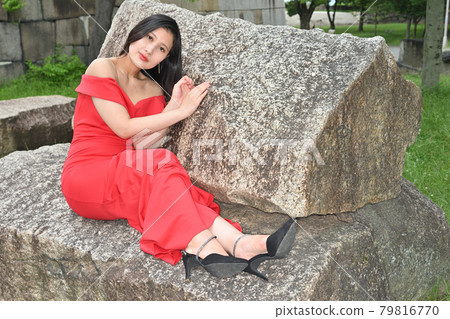 Woman sitting on a rock Woman sitting on a rock 79816770