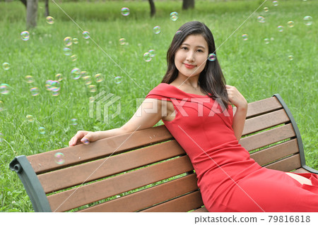 A woman sitting on a bench A woman sitting on a bench 79816818