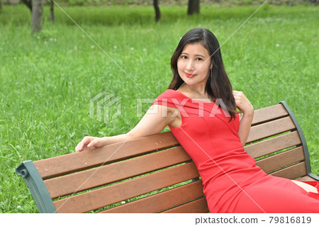 A woman sitting on a bench 79816819