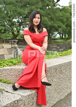 Woman sitting on a stone wall Woman sitting on a stone wall 79816995