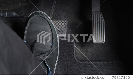 Man foot and accelerator and brake pedal inside the car or vehicle and copy space which black color leather shoe stepped on it for speed up or control automobile pace power. Automobile Driving concept 79817390