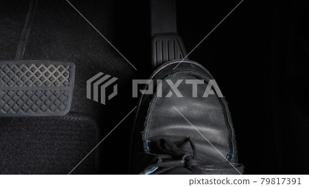 Man foot and accelerator and brake pedal inside the car or vehicle and copy space which black color leather shoe stepped on it for speed up or control automobile pace power. Automobile Driving concept Man foot and accelerator and brake pedal inside the car or vehicle and copy space which black color leather shoe stepped on it for speed up or control automobile pace power. Automobile Driving concept 79817391