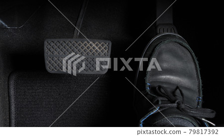 Man foot and accelerator and brake pedal inside the car or vehicle and copy space which black color leather shoe stepped on it for speed up or control automobile pace power. Automobile Driving concept Man foot and accelerator and brake pedal inside the car or vehicle and copy space which black color leather shoe stepped on it for speed up or control automobile pace power. Automobile Driving concept 79817392