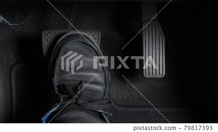 Man foot and accelerator and brake pedal inside the car or vehicle and copy space which black color leather shoe stepped on it for speed up or control automobile pace power. Automobile Driving concept 79817393