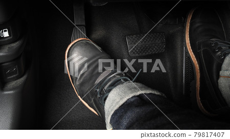 Man foot and accelerator and brake pedal inside the car or vehicle and copy space which black color leather shoe stepped on it for speed up or control automobile pace power. Automobile Driving concept 79817407