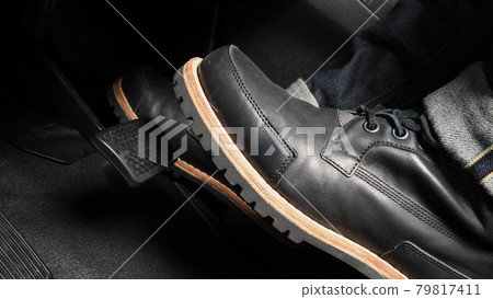 Man foot and accelerator and brake pedal inside the car or vehicle and copy space which black color leather shoe stepped on it for speed up or control automobile pace power. Automobile Driving concept Man foot and accelerator and brake pedal inside the car or vehicle and copy space which black color leather shoe stepped on it for speed up or control automobile pace power. Automobile Driving concept 79817411