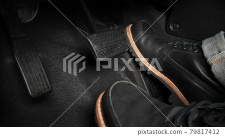 Man foot and accelerator and brake pedal inside the car or vehicle and copy space which black color leather shoe stepped on it for speed up or control automobile pace power. Automobile Driving concept Man foot and accelerator and brake pedal inside the car or vehicle and copy space which black color leather shoe stepped on it for speed up or control automobile pace power. Automobile Driving concept 79817412