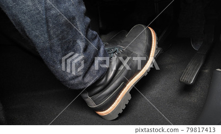 Man foot and accelerator and brake pedal inside the car or vehicle and copy space which black color leather shoe stepped on it for speed up or control automobile pace power. Automobile Driving concept Man foot and accelerator and brake pedal inside the car or vehicle and copy space which black color leather shoe stepped on it for speed up or control automobile pace power. Automobile Driving concept 79817413