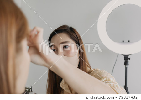 Woman makeup artist is at work and wearing makeup on her model. 79817432