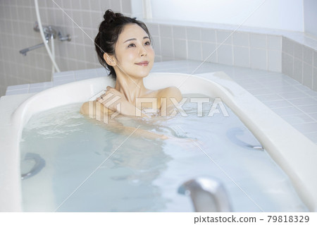A woman soaking in a bathtub A woman soaking in a bathtub 79818329