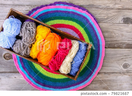 Knitted mat and colorful skeins of wollen yarn 79821687