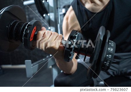 Arms up for middle-aged men who train with dumbbells at the gym Arms up for middle-aged men who train with dumbbells at the gym 79823607