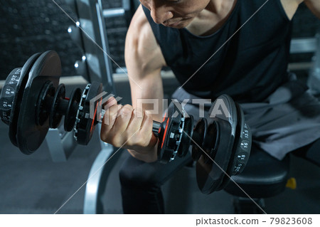 Arms up for middle-aged men who train with dumbbells at the gym 79823608