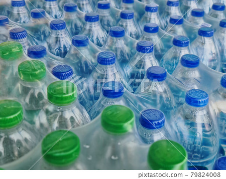 High Angle View of Packs of Bottled Drinking Water with Blue and Green Caps 79824008