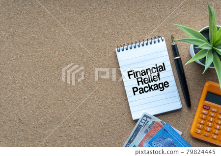 FINANCIAL RELIEF PACKAGE text with notepad, calculator, decorative plant, money banknotes, keyboard and fountain pen on wooden background.und FINANCIAL RELIEF PACKAGE text with notepad, calculator, decorative plant, money banknotes, keyboard and fountain pen on wooden background.und 79824445