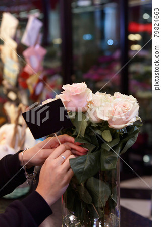 Flower seller is holding an empty sign for the price of roses. Flower seller is holding an empty sign for the price of roses. 79824663
