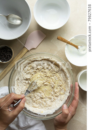 Female hands mixing raw dough, cooking bundt cake in glass bowl, top view. Step by step recipe. Female hands mixing raw dough, cooking bundt cake in glass bowl, top view. Step by step recipe. 79827638