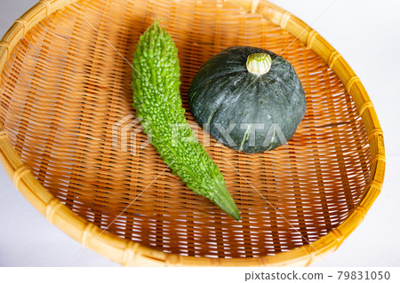 Harvesting in the vegetable garden. Freshly picked bitter gourd and pumpkin 79831050