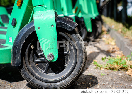 Riga, Latvia - July 18, 2022: Bolt electric rental scooters are parked on a sidewalk in Riga. Defocused Riga, Latvia - July 18, 2022: Bolt electric rental scooters are parked on a sidewalk in Riga. Defocused 79831202