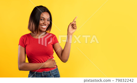 African American Woman Pointing Finger Aside Over Yellow Background 79832242
