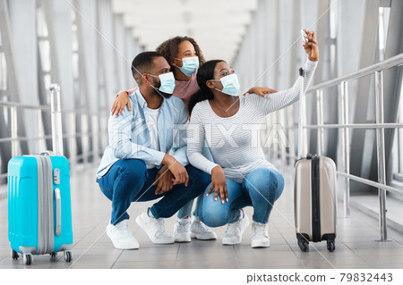 Black family in face masks taking selfie in airport Black family in face masks taking selfie in airport 79832443
