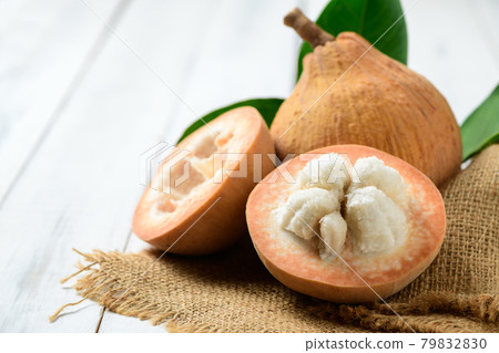 Half Santol on white wood background, Santol has sour taste 79832830