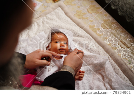 baby girl on the table in the church during baptism. the rite of chrismation.  79834901