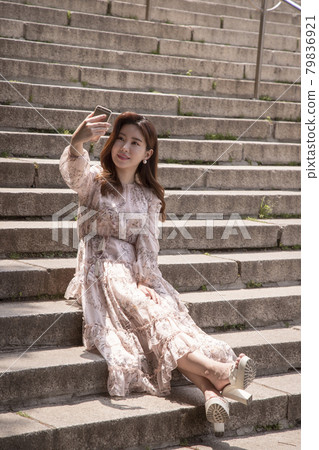 女人坐在樓梯上看手機 79836921