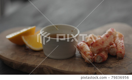 Slow motion gimbal shot of crab leg meat on a olive board with sweet lemon and dip sauce Slow motion gimbal shot of crab leg meat on a olive board with sweet lemon and dip sauce 79836956