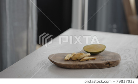 Sublimated mango next to fresh mango on olive board on white oak table Sublimated mango next to fresh mango on olive board on white oak table 79837032