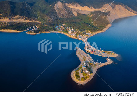 Aerial view of coastline with sea, mountains, canyon and lighthouse on island with sunset light Aerial view of coastline with sea, mountains, canyon and lighthouse on island with sunset light 79837287