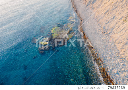 Aerial view of sea surface with stones and coastline Aerial view of sea surface with stones and coastline 79837289
