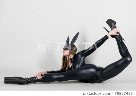 Sexy beautiful woman pole dancer posing in latex costume on background. Easter bunny concept. 79837456