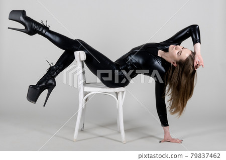 Sexy beautiful woman pole dancer posing in latex costume on background. 79837462