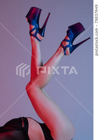 Beautiful female legs in blue high-heeled shoes for pole dance. 79837649