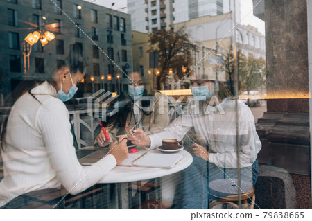 Friends girls met in a cafe. Wear medical protective masks. Friends girls met in a cafe. Wear medical protective masks. 79838665
