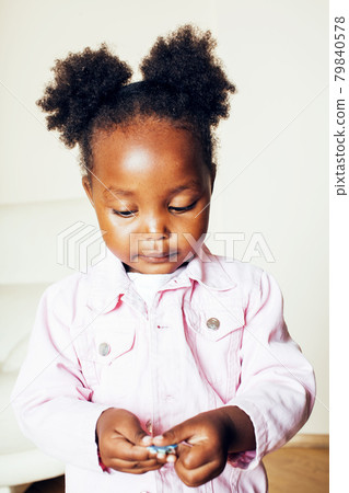 little cute african american girl playing with animal toys at home, pretty adorable princess in interior happy smiling, lifestyle real people concept 79840578