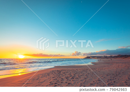 Dramatic sunset with people fishing from the beach 79842983