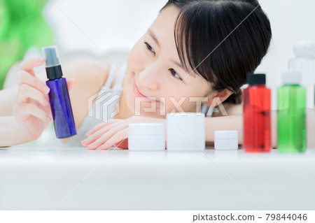A young woman in a loungewear doing skin care at home in the room A young woman in a loungewear doing skin care at home in the room 79844046