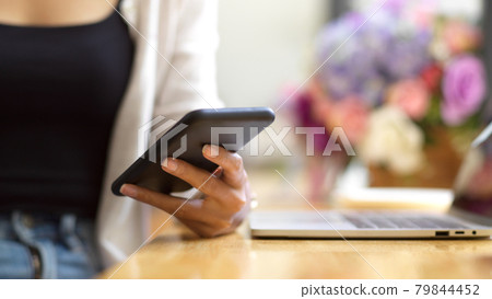 Cropped shot of female texting on smartphone 79844452