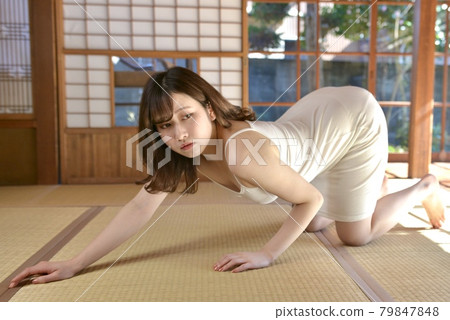 一位身著吊帶背心的年輕女子在老民居的日式房間裡擺姿勢 79847848