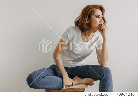 Cool looks woman in white t-shirt and jean relax in her apartment room. Cool looks woman in white t-shirt and jean relax in her apartment room. 79904216
