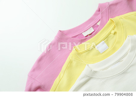 Yellow, pink and white sweatshirts, space for text 79904808