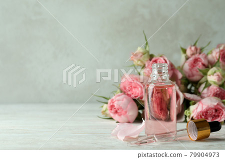 Bottle with rose essential oil on white wooden table Bottle with rose essential oil on white wooden table 79904973