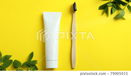 Eco friendly toothbrush, toothpaste and branches on yellow background 79905015