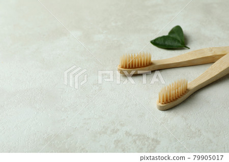 Eco friendly toothbrushes and leaves on white textured background 79905017